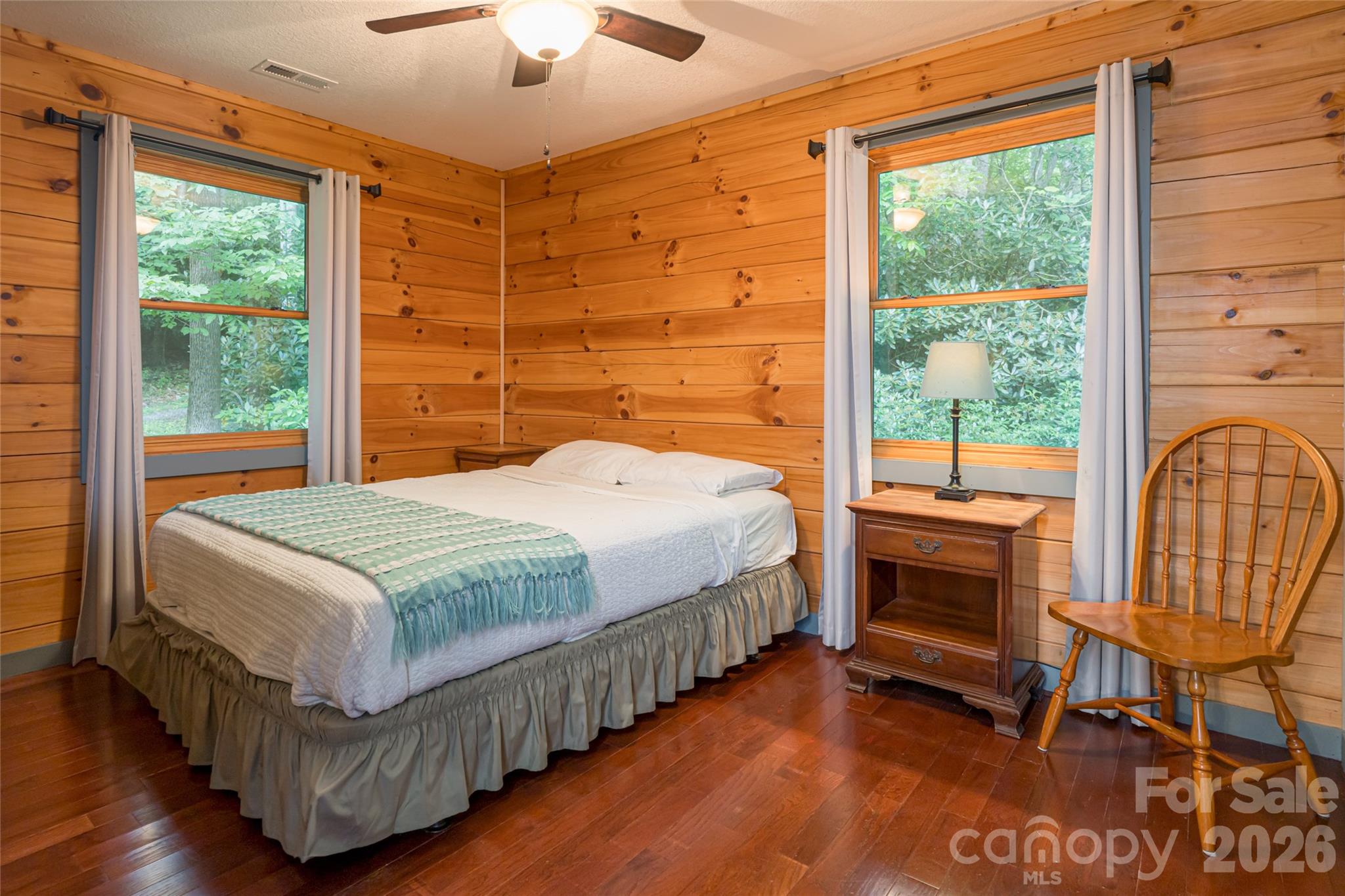 4035 Bald Creek Road Clyde, NC 28721 - Photo 19 of 43 a bedroom with a bed a chair and a large window with wooden floor