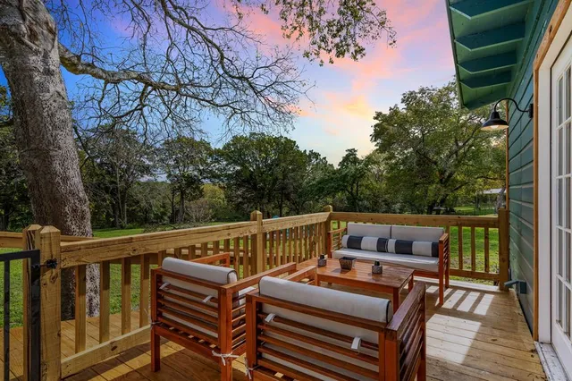 a view of a balcony with wooden floor and outdoor seating