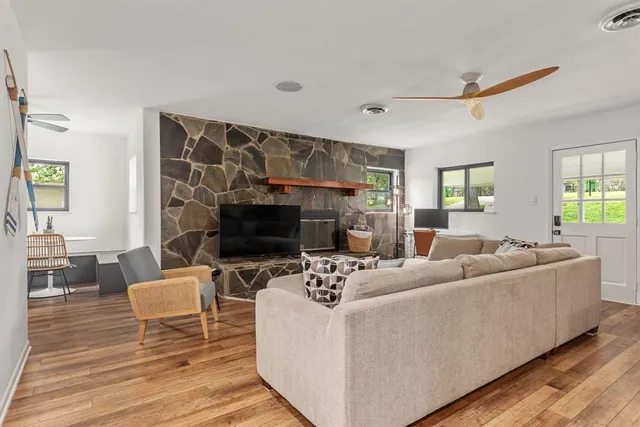 a living room with furniture a fireplace and a flat screen tv