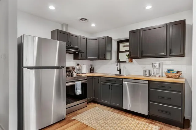 a kitchen with stainless steel appliances granite countertop a refrigerator stove a sink and dishwasher