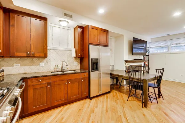 a kitchen with stainless steel appliances granite countertop a sink and wooden cabinets