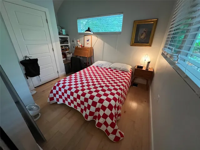 a bedroom with a bed and wooden floor