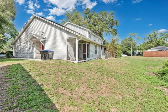 a front view of house with yard and trees in the background