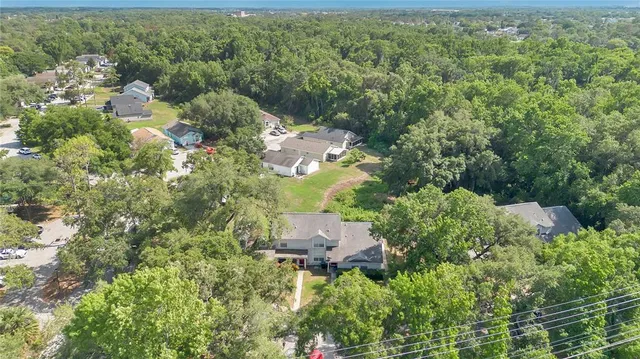 an aerial view of residential house with outdoor space and trees all around