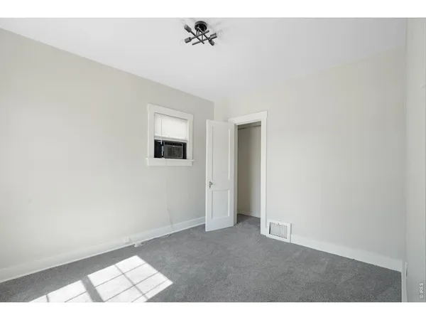 an empty room with windows and cabinet