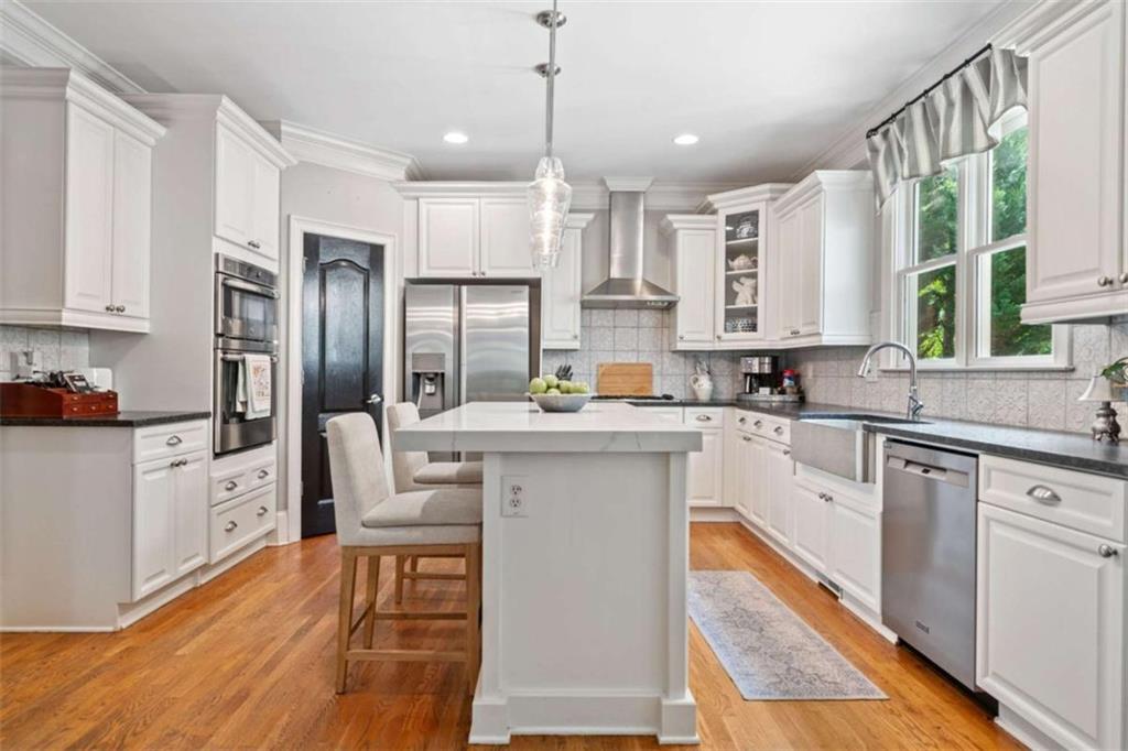 380 Creek Point Milton, GA 30004 - Photo 12 of 74 a kitchen with stainless steel appliances kitchen island granite countertop a refrigerator a sink dishwasher a stove and white cabinets with wooden floor