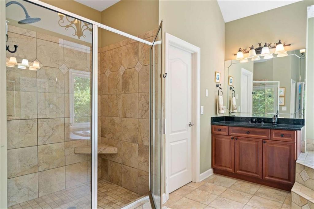 380 Creek Point Milton, GA 30004 - Photo 40 of 74 a bathroom with a granite countertop sink a mirror and a shower