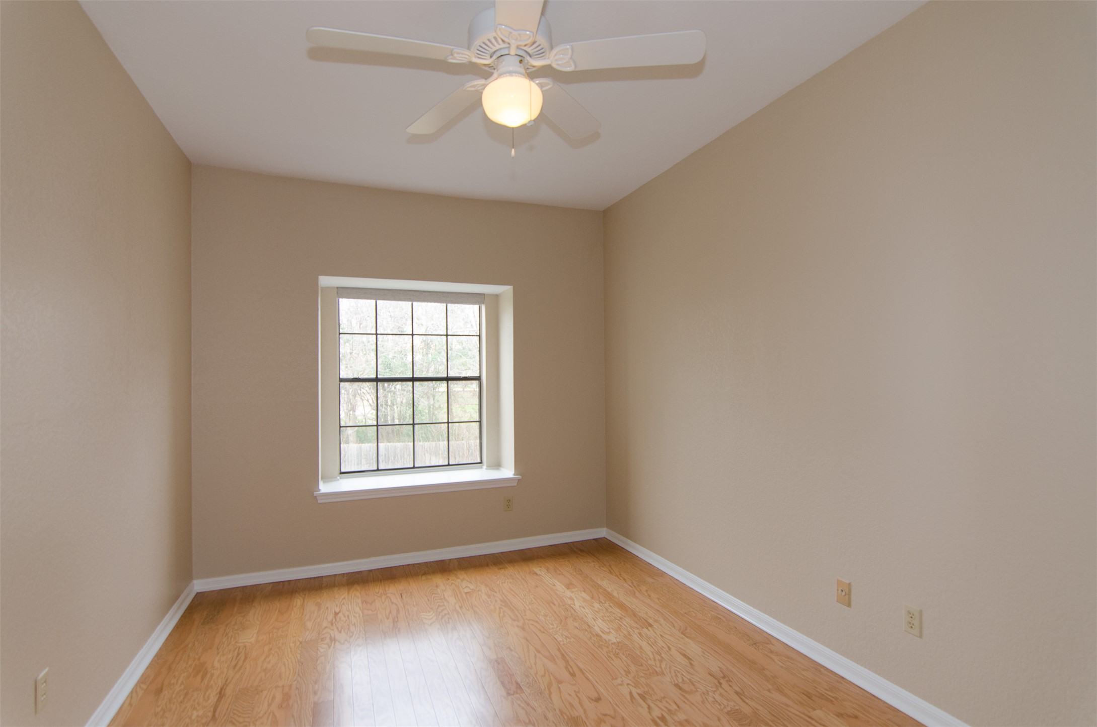10819 Crown Colony Drive, Unit 38 Austin, TX 78747 - Photo 15 of 28 an empty room with wooden floor ceiling fan and windows