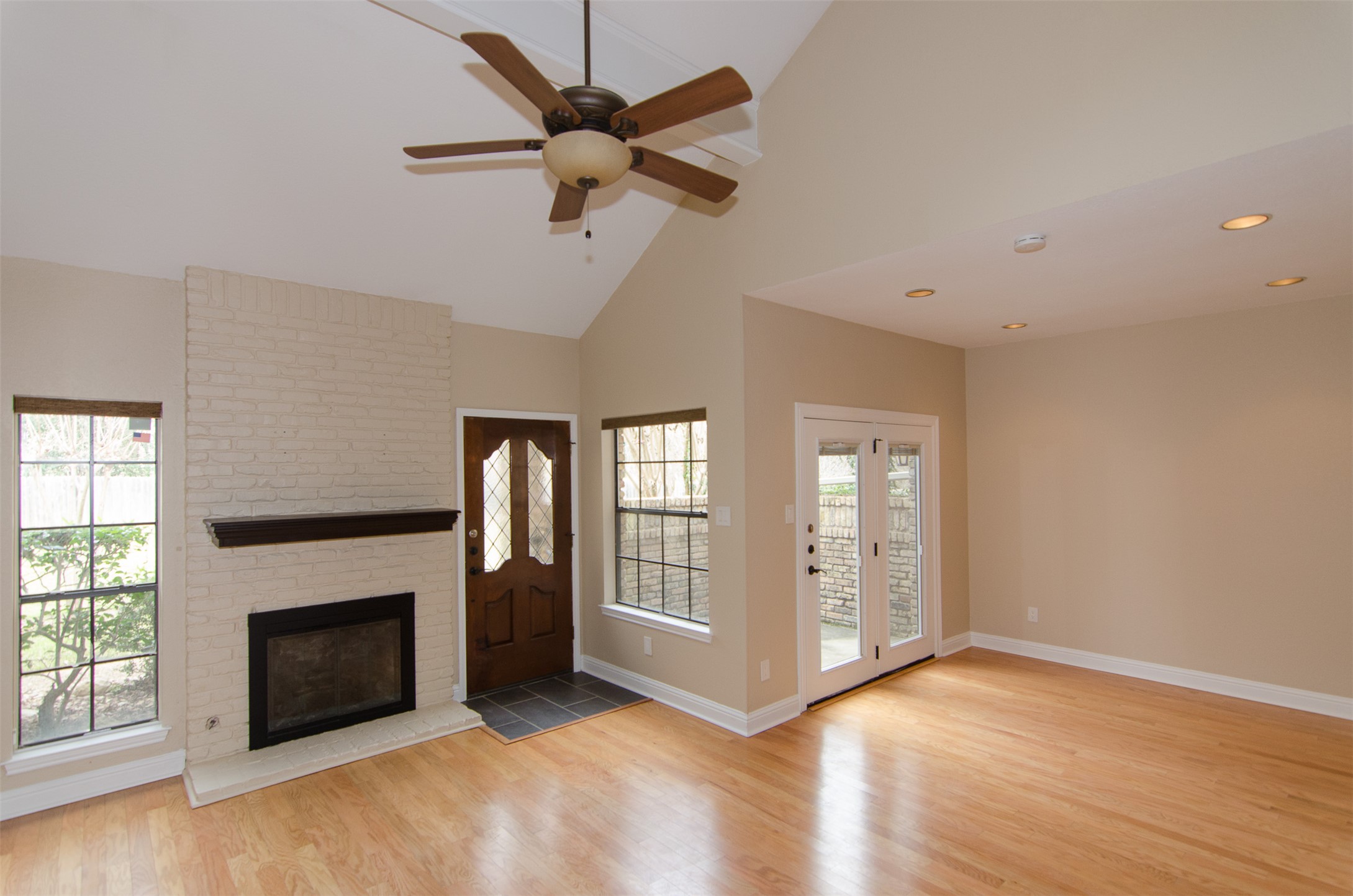10819 Crown Colony Drive, Unit 38 Austin, TX 78747 - Photo 9 of 28 an empty room with windows fireplace and a kitchen view