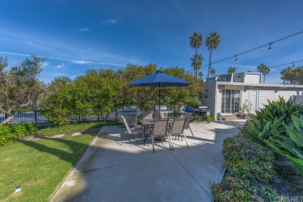 3101 Peninsula Road, Unit 108 Oxnard, CA 93035 - Photo 15 of 24 a view of a patio with a table and chairs under an umbrella