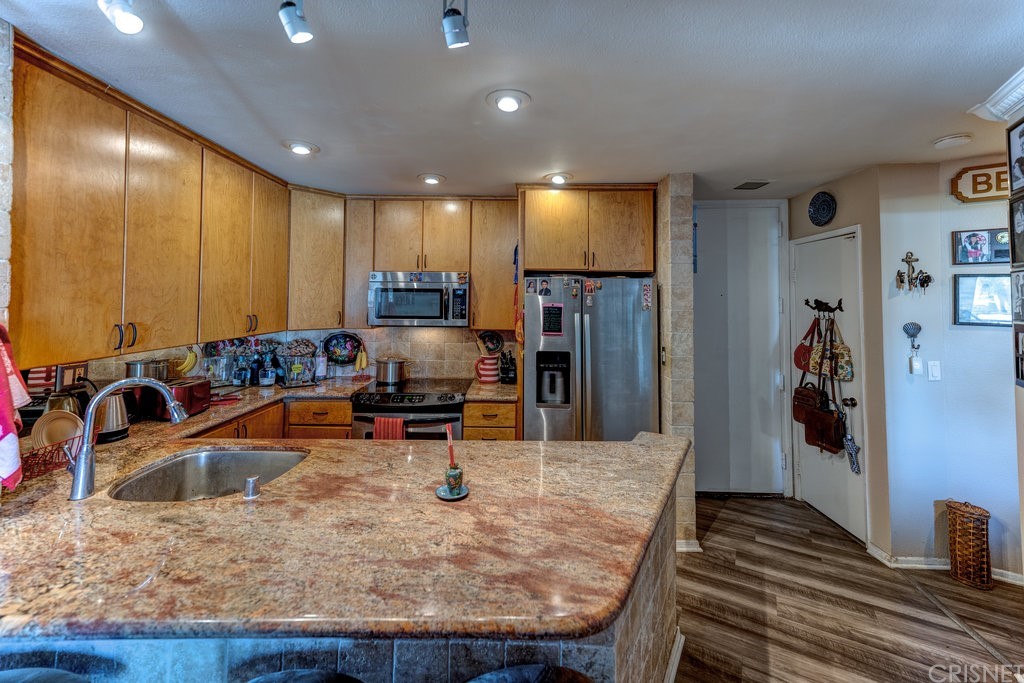 3101 Peninsula Road, Unit 108 Oxnard, CA 93035 - Photo 5 of 24 a view of a kitchen with kitchen island a large window and stainless steel appliances