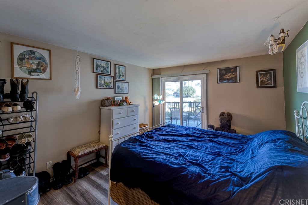 3101 Peninsula Road, Unit 108 Oxnard, CA 93035 - Photo 9 of 24 a bedroom with a bed and wooden floor