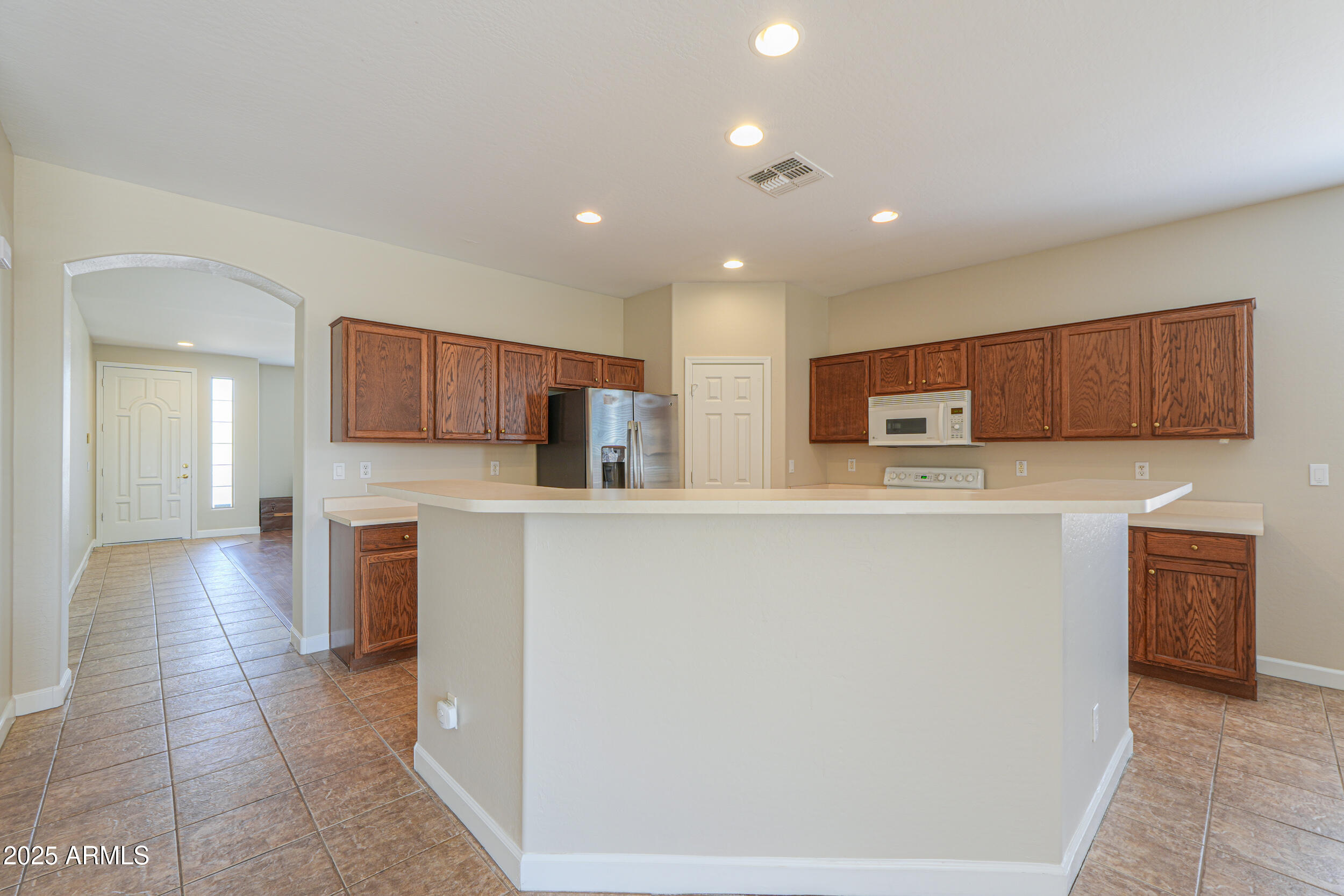 43223 West Venture Road Maricopa, AZ 85138 - Photo 26 of 70 a kitchen with stainless steel appliances a refrigerator and a stove top oven