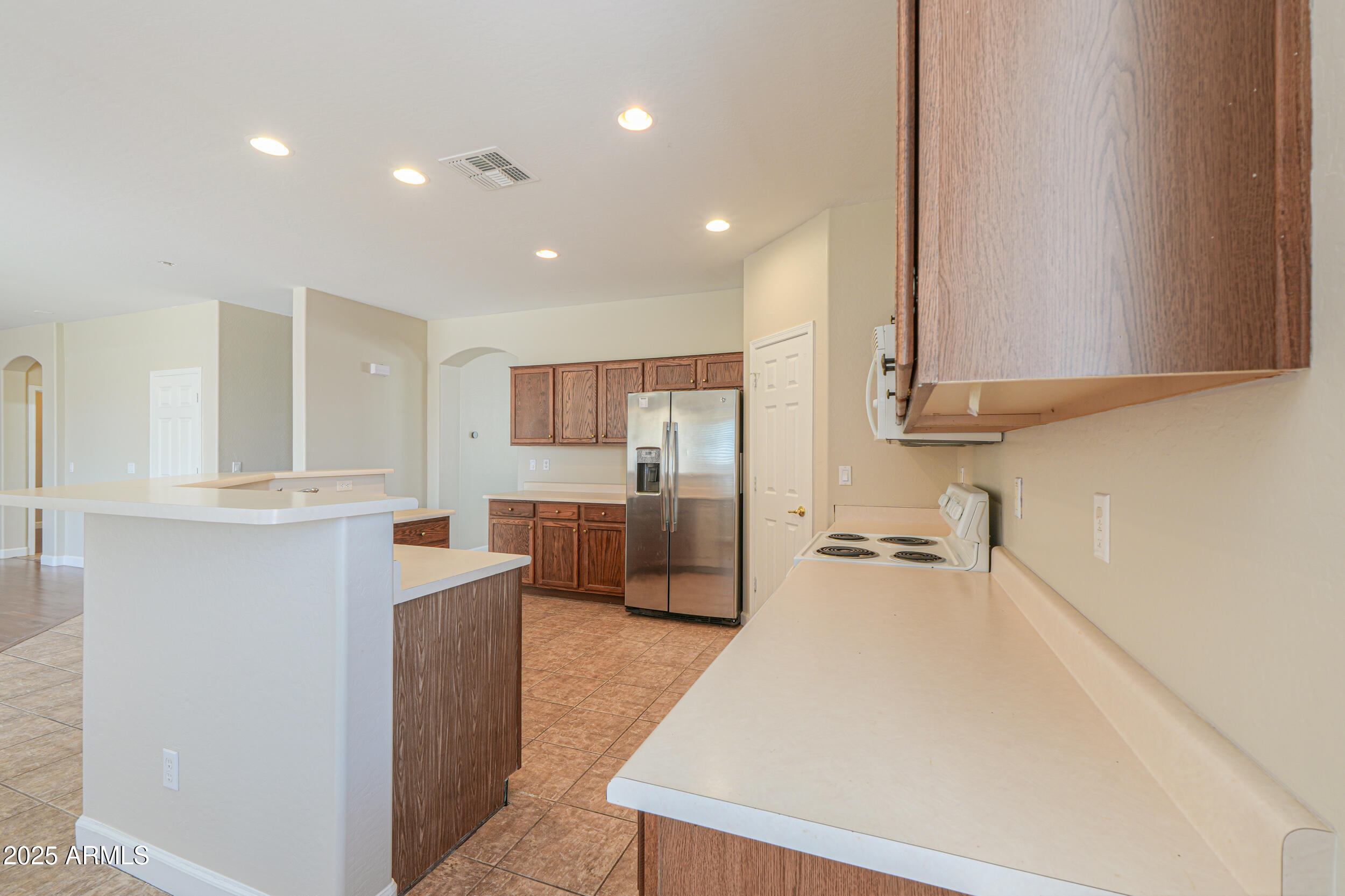 43223 West Venture Road Maricopa, AZ 85138 - Photo 27 of 70 a large kitchen with kitchen island a sink a stove and a refrigerator