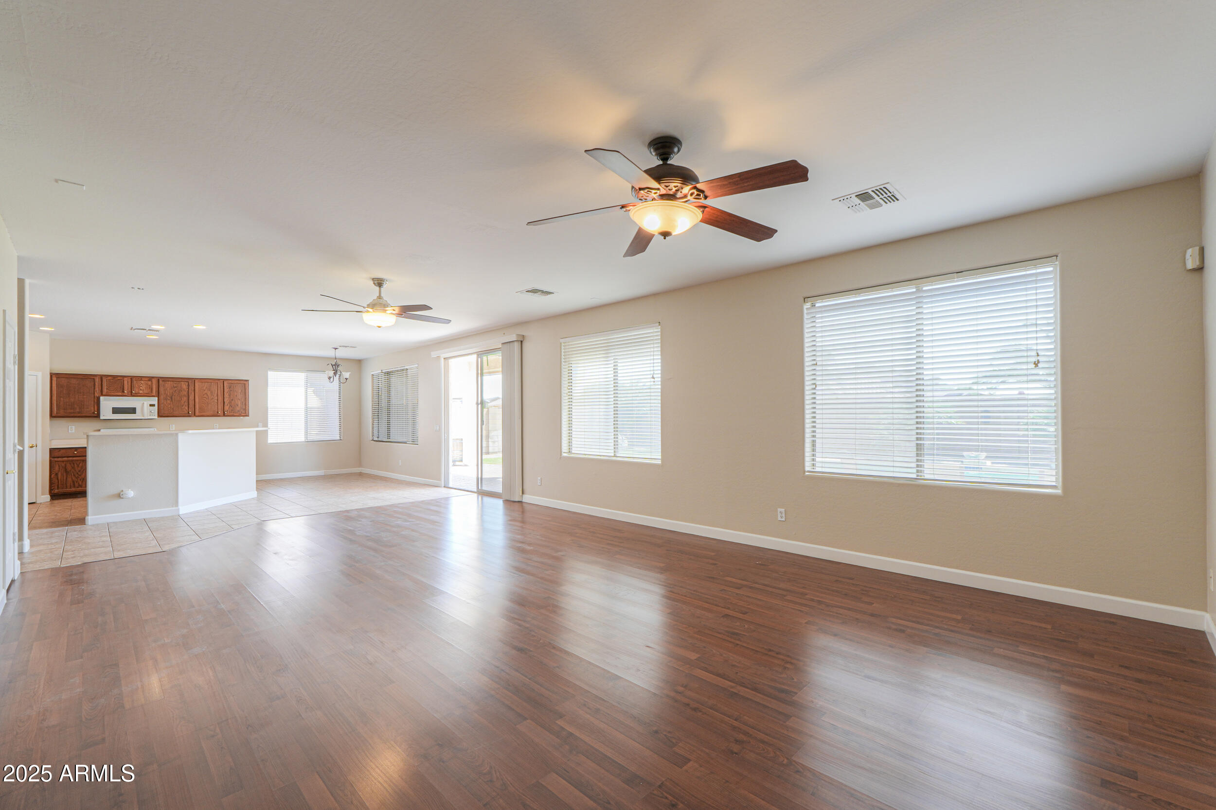 43223 West Venture Road Maricopa, AZ 85138 - Photo 32 of 70 a view of an empty room with wooden floor and a window