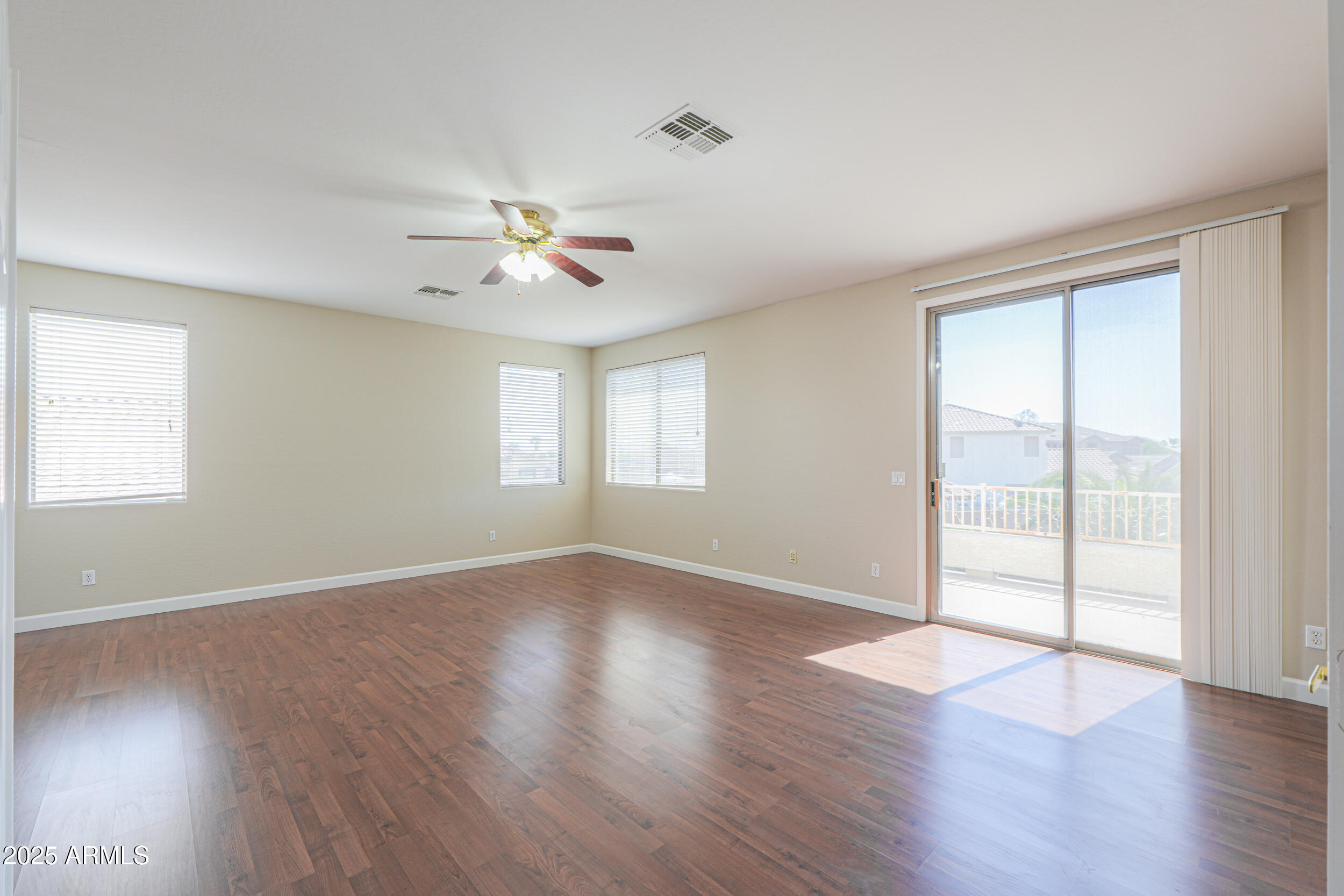 43223 West Venture Road Maricopa, AZ 85138 - Photo 53 of 70 an empty room with wooden floor and windows