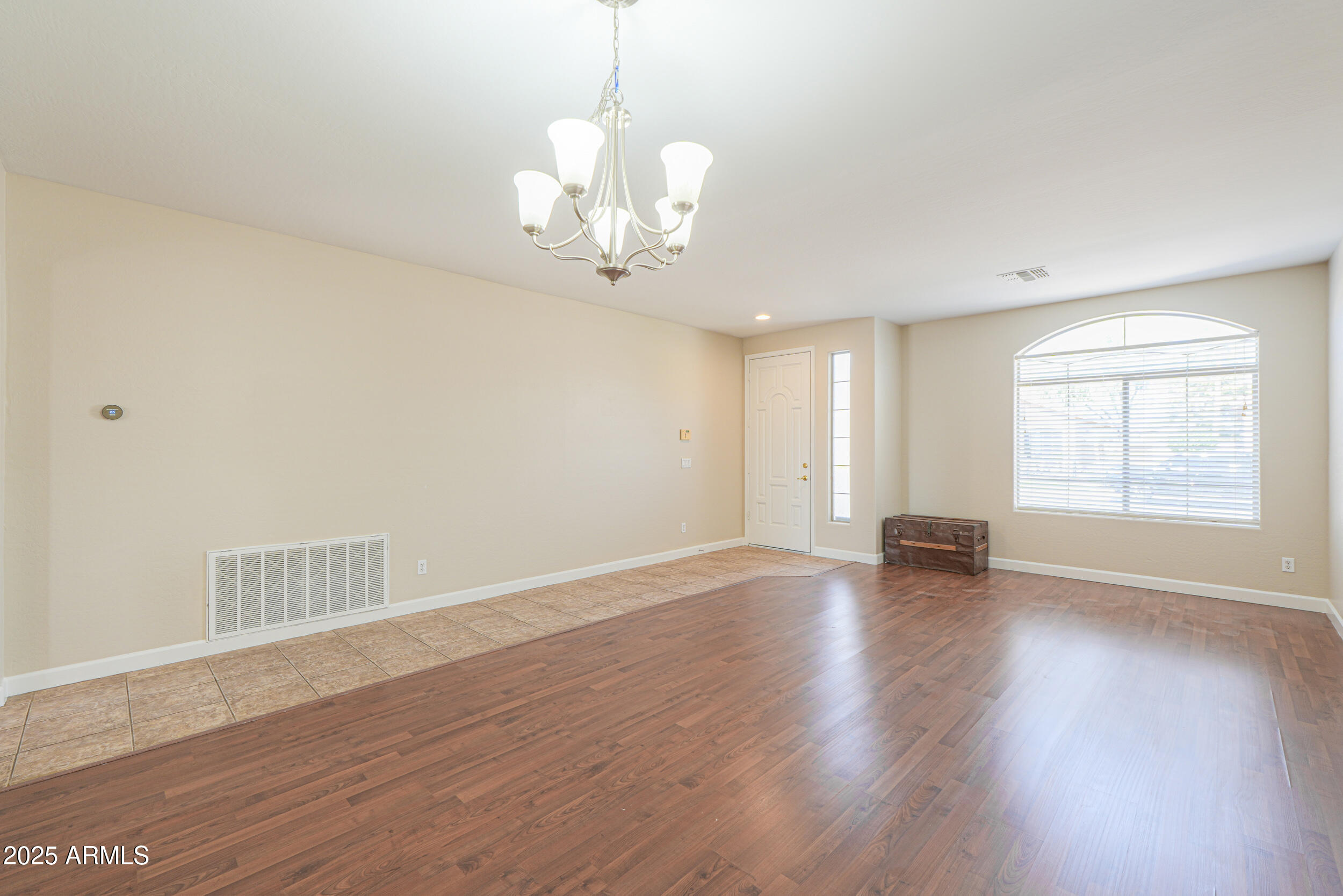 43223 West Venture Road Maricopa, AZ 85138 - Photo 8 of 70 a view of an empty room with wooden floor and a window
