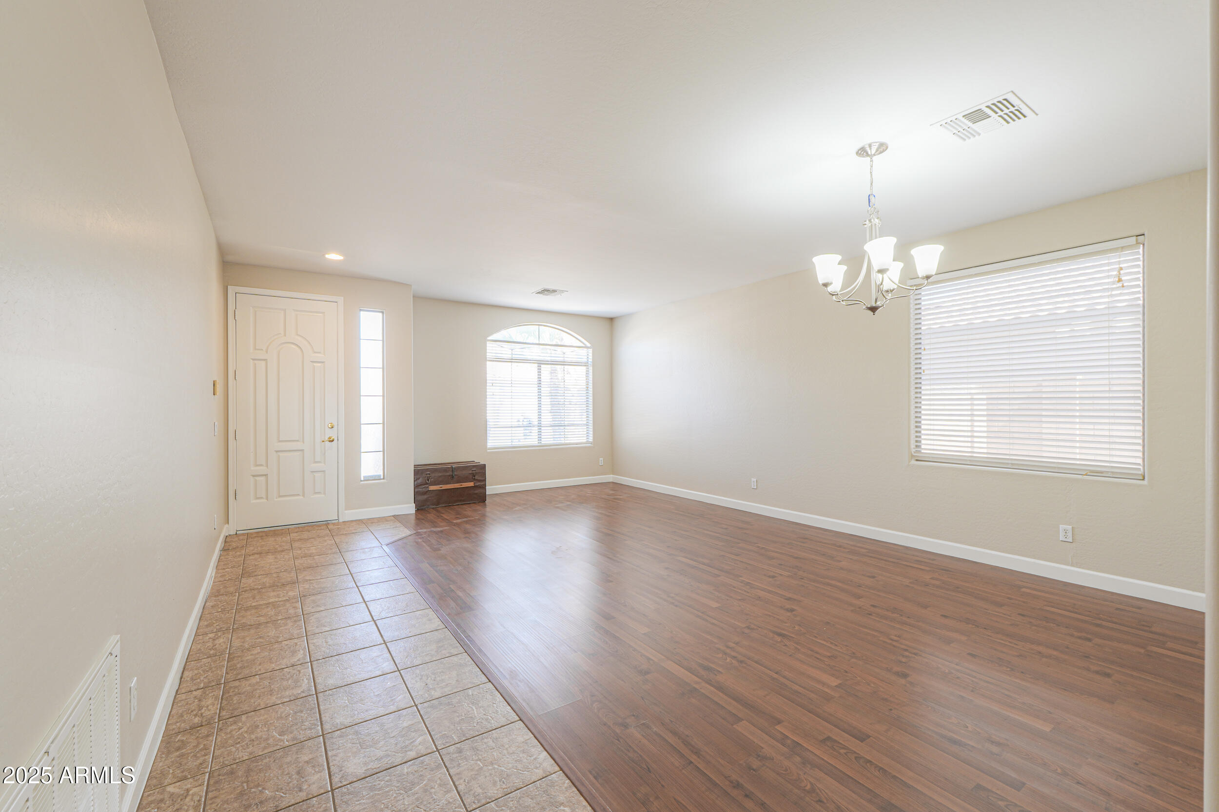 43223 West Venture Road Maricopa, AZ 85138 - Photo 9 of 70 an empty room with wooden floor and windows