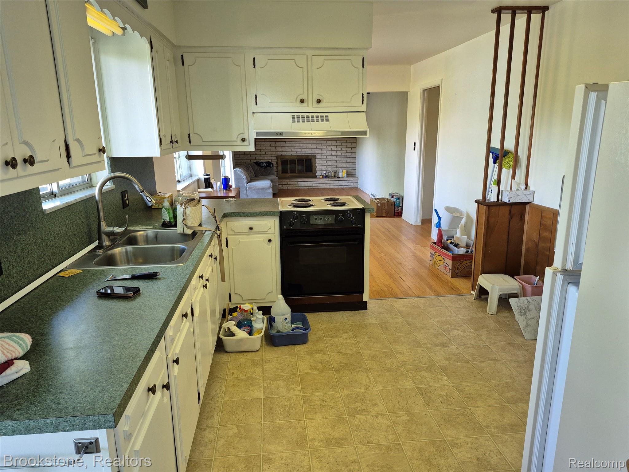 4295 Sashabaw Road Waterford, MI 48329 - Photo 16 of 37 Kitchen featuring white cabinetry, a double basin stainless steel sink, and a black electric range