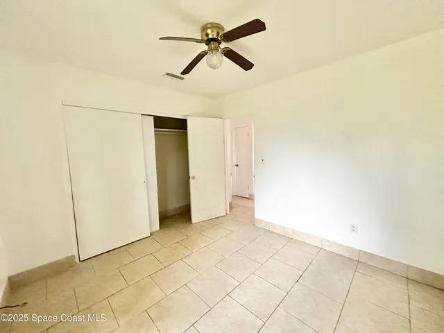 a view of empty room with ceiling fan