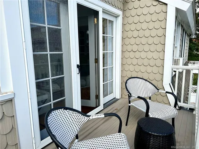 a view of balcony with wooden floor and seating space
