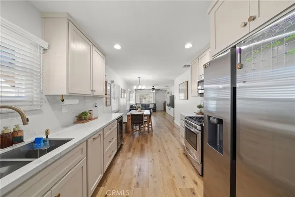 a kitchen with kitchen island a counter top space a sink stainless steel appliances and cabinets