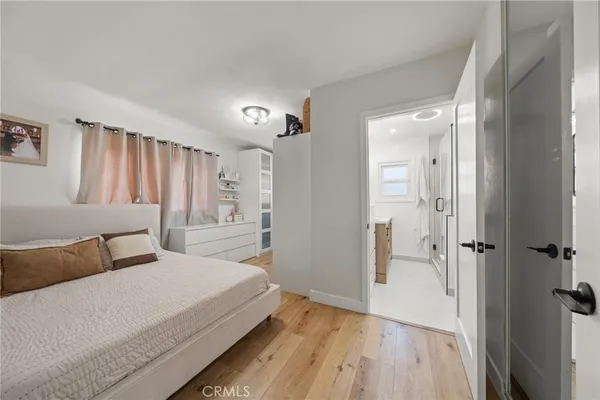 a bedroom with a bed and wooden floor