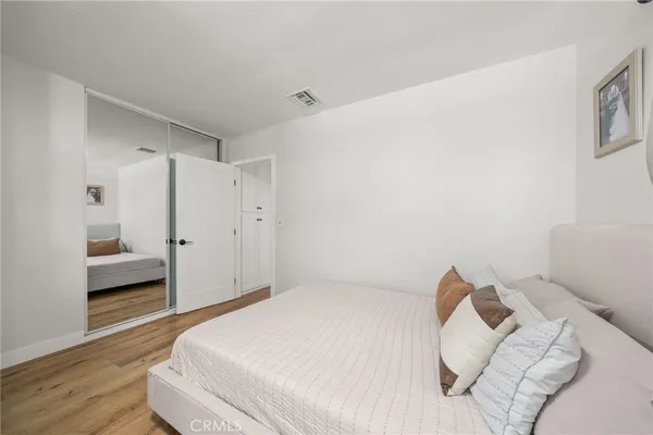 a bedroom with a bed and a refrigerator