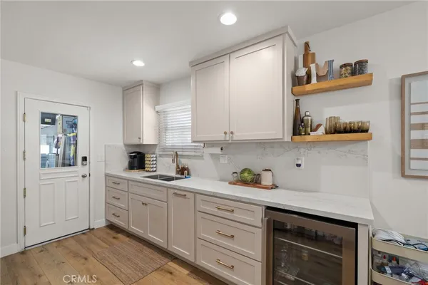 a kitchen with white cabinets and sink