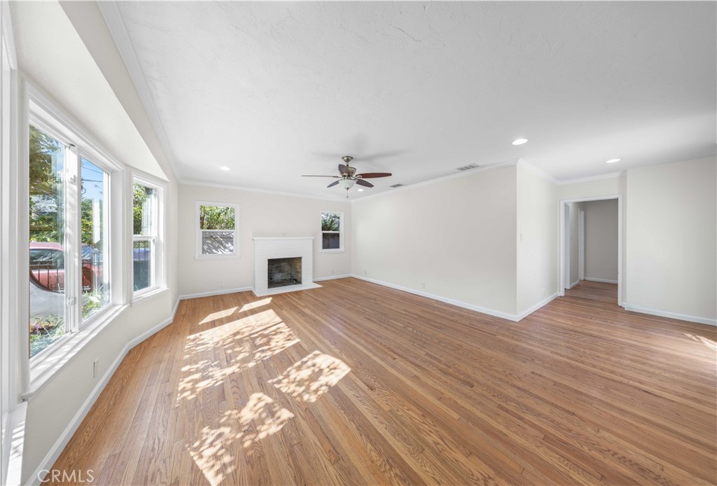 2074 Summit Avenue Pasadena, CA 91103 - Photo 2 of 23 an empty room with wooden floor chandelier fan and windows