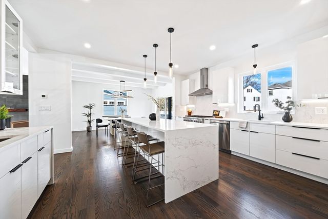 a kitchen with white cabinets and chairs