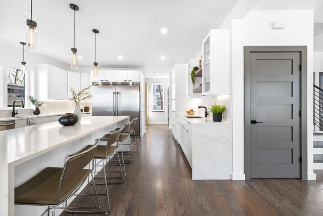 a kitchen with kitchen island a wooden floor and white appliances