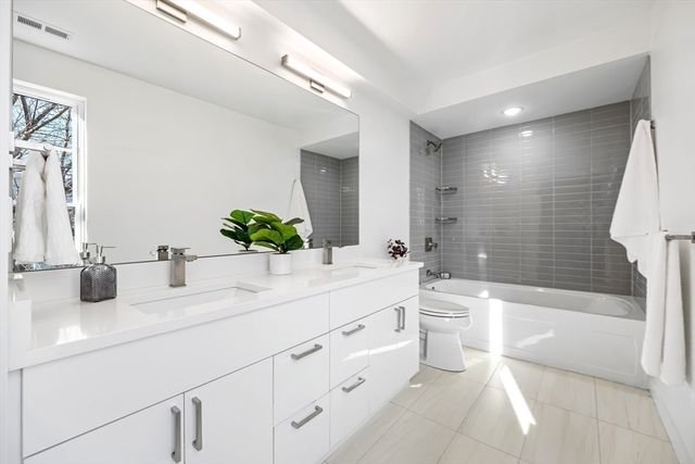 a bathroom with a double vanity sink toilet and shower