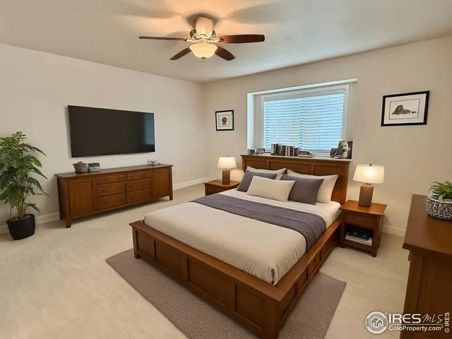 a spacious bedroom with a bed and a flat screen tv