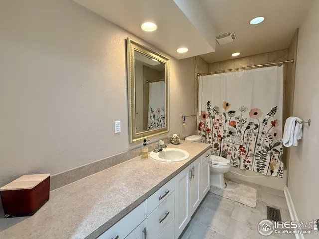 a spacious bathroom with a double vanity sink mirror and shower