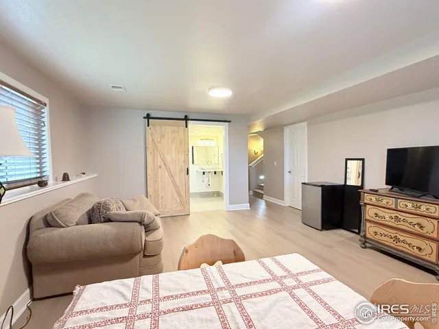 a bedroom with furniture and a flat screen tv