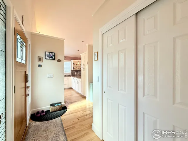 a view of a hallway with wooden floor and furniture