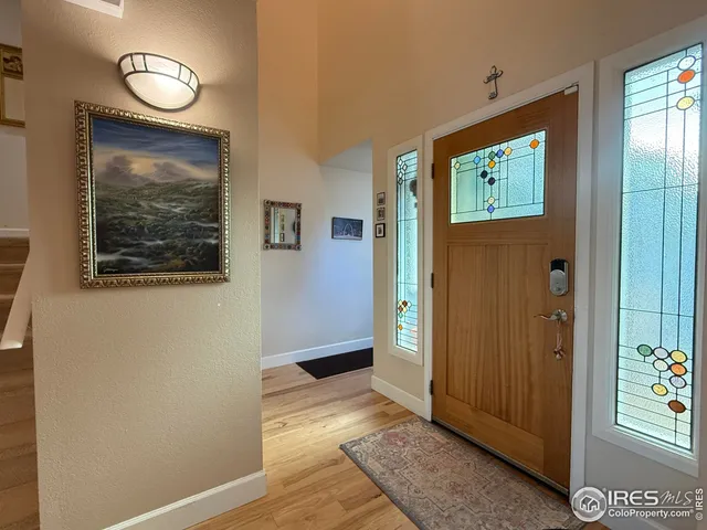 an empty room with wooden floor closet and windows
