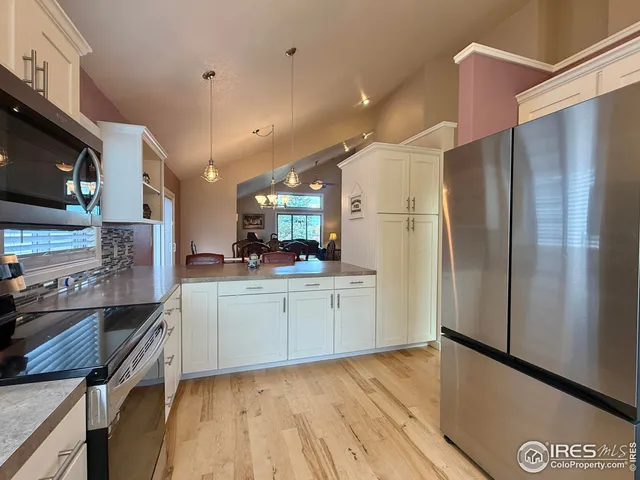 a kitchen with a refrigerator and a stove top oven
