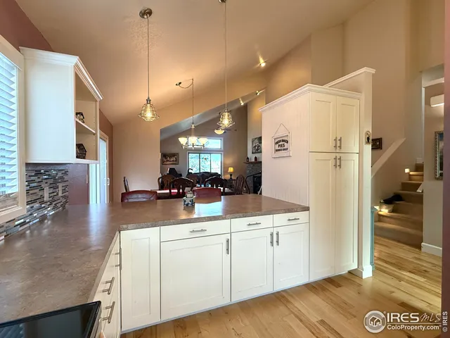 a kitchen with white cabinets and sink
