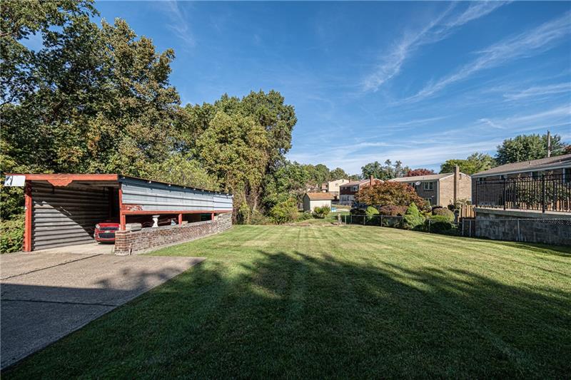 103 Louis Drive McKees Rocks, PA 15136 - Photo 24 of 24 View of the impressive, level yard with woods in the background. Wow! Sizable 1-car carport shown to the left. (The car in the carport is NOT for sale.)