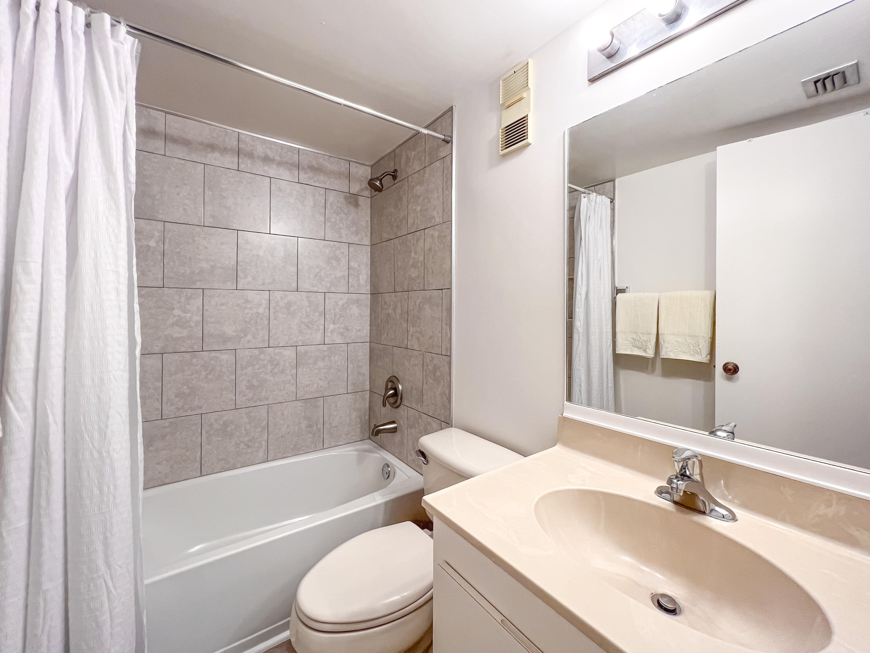 353 Highway 1, Unit B309 Jupiter, FL 33477 - Photo 11 of 24 a bathroom with a bathtub shower sink vanity mirror and toilet