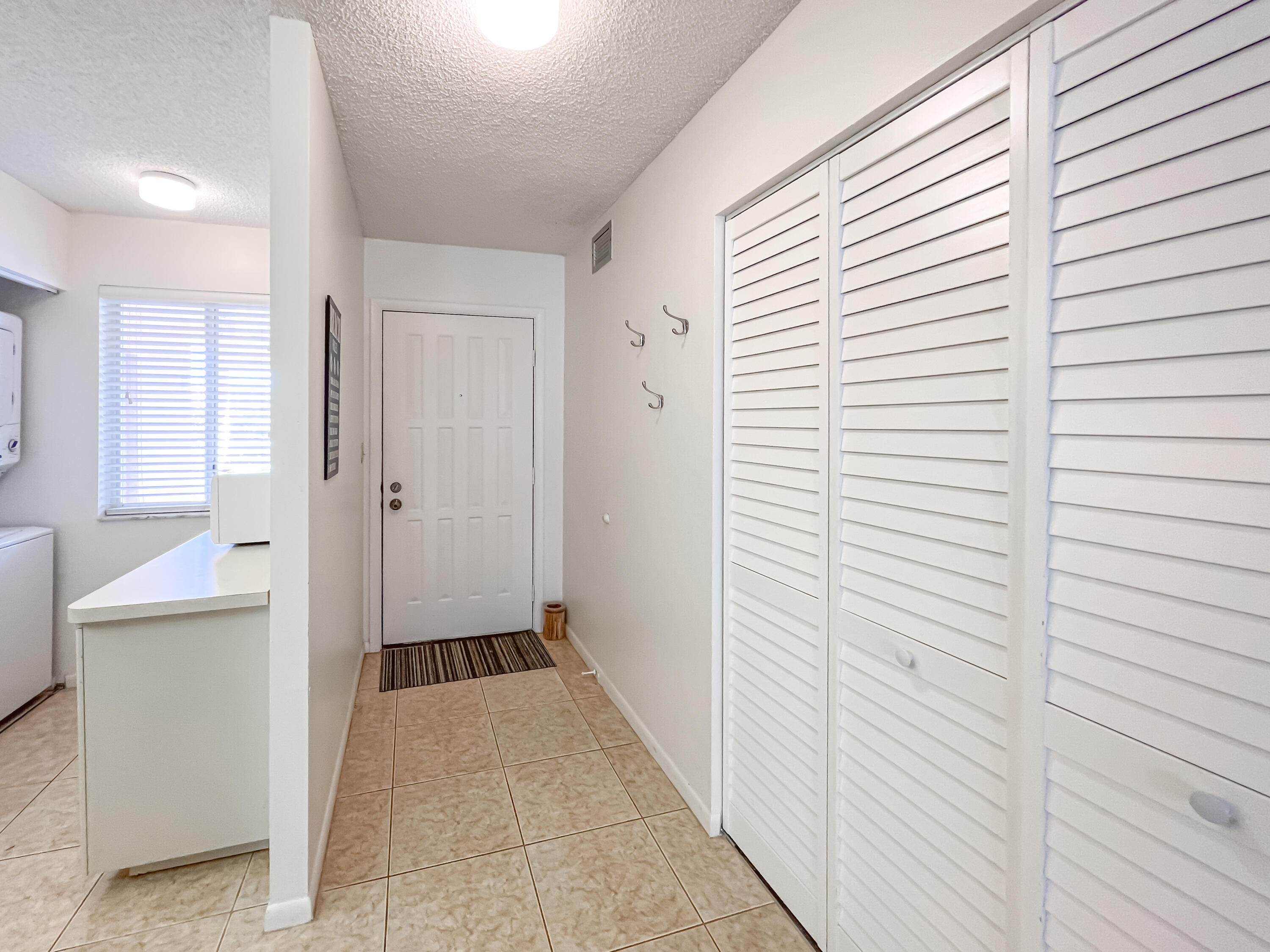 353 Highway 1, Unit B309 Jupiter, FL 33477 - Photo 5 of 24 a view of a hallway with a white cabinet