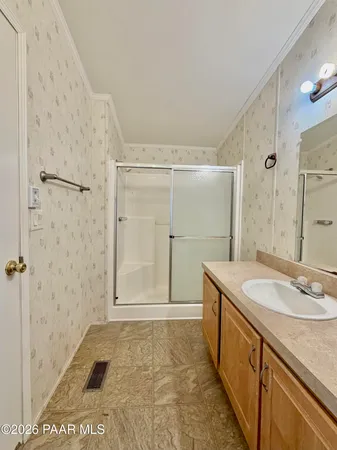 a bathroom with a granite countertop sink a mirror and a shower