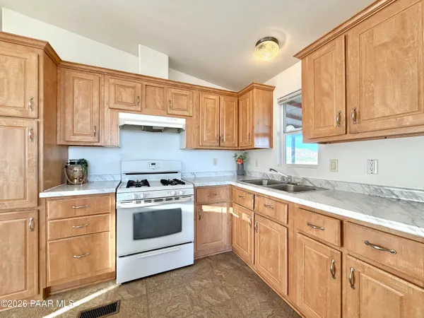 a kitchen with granite countertop white cabinets and white appliances