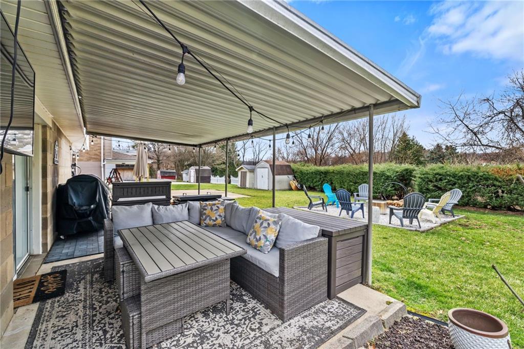 1075 Fiddleback Drive McKees Rocks, PA 15136 - Photo 26 of 34 a view of a patio with couches table and chairs under an umbrella