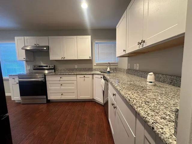 a kitchen with stainless steel appliances granite countertop a stove a sink and a microwave