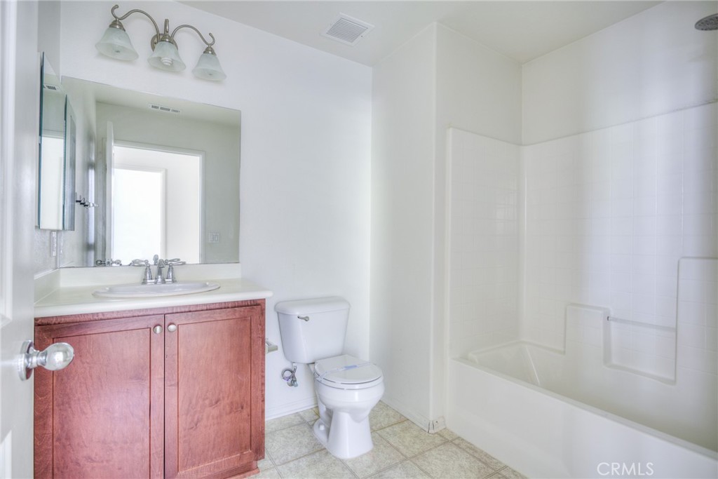 16001 Chase Road, Unit 53 Fontana, CA 92336 - Photo 14 of 32 a bathroom with a granite countertop sink toilet a large mirror a bathtub and shower