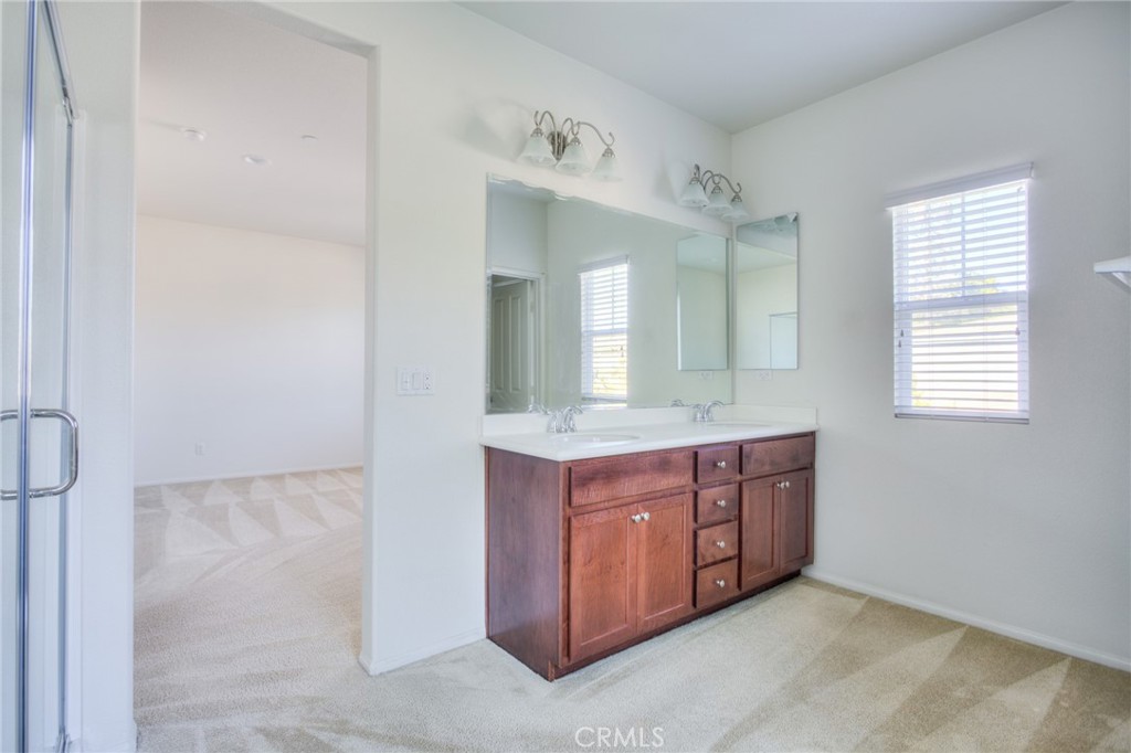 16001 Chase Road, Unit 53 Fontana, CA 92336 - Photo 22 of 32 a bathroom with a granite countertop sink and a mirror