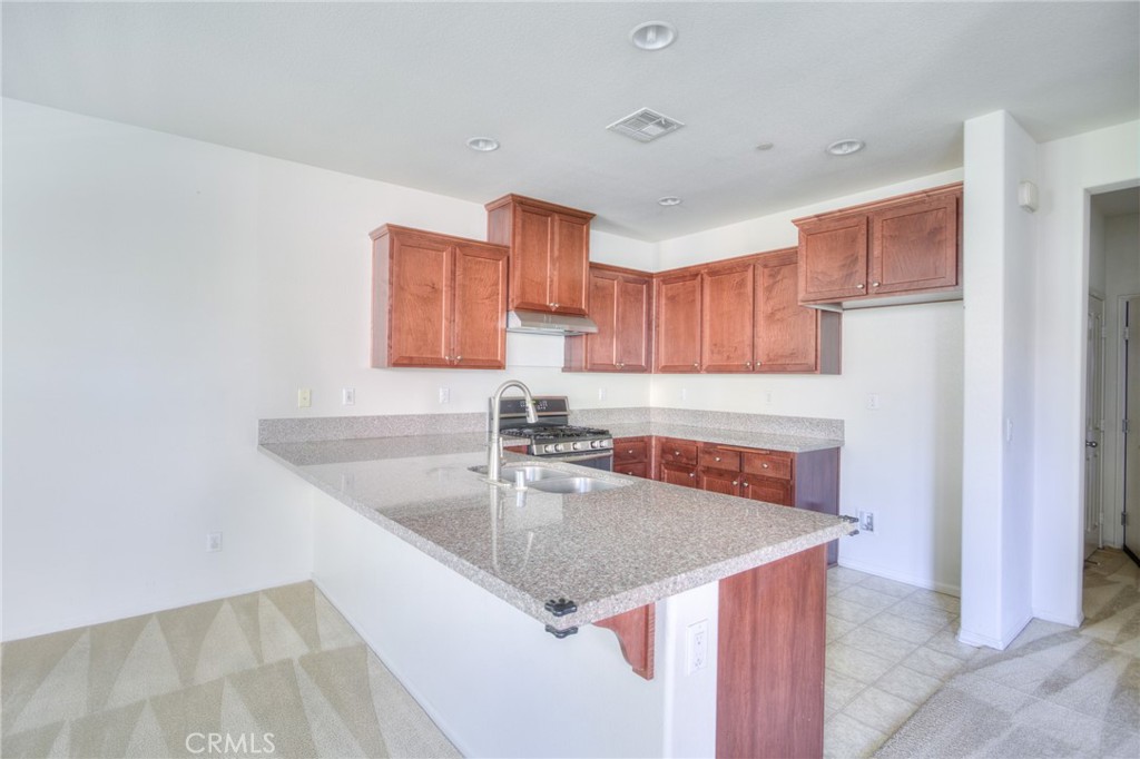 16001 Chase Road, Unit 53 Fontana, CA 92336 - Photo 9 of 32 a kitchen with a sink a microwave and cabinets